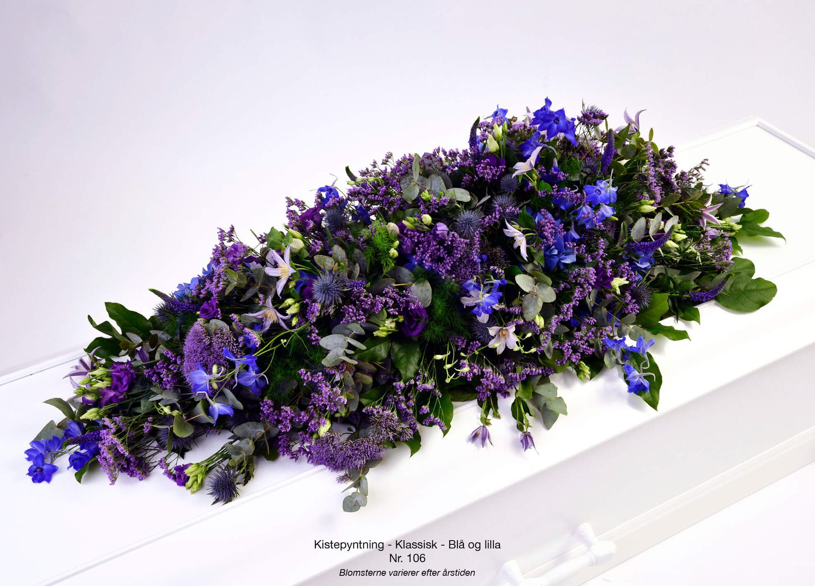 Floral arrangement styling: purple and blue casket spray with classical composition of chrysanthemums and iris