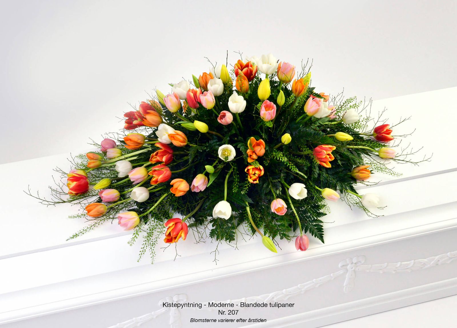 Product photography art direction showcasing vibrant mixed tulip arrangement in warm spring tones