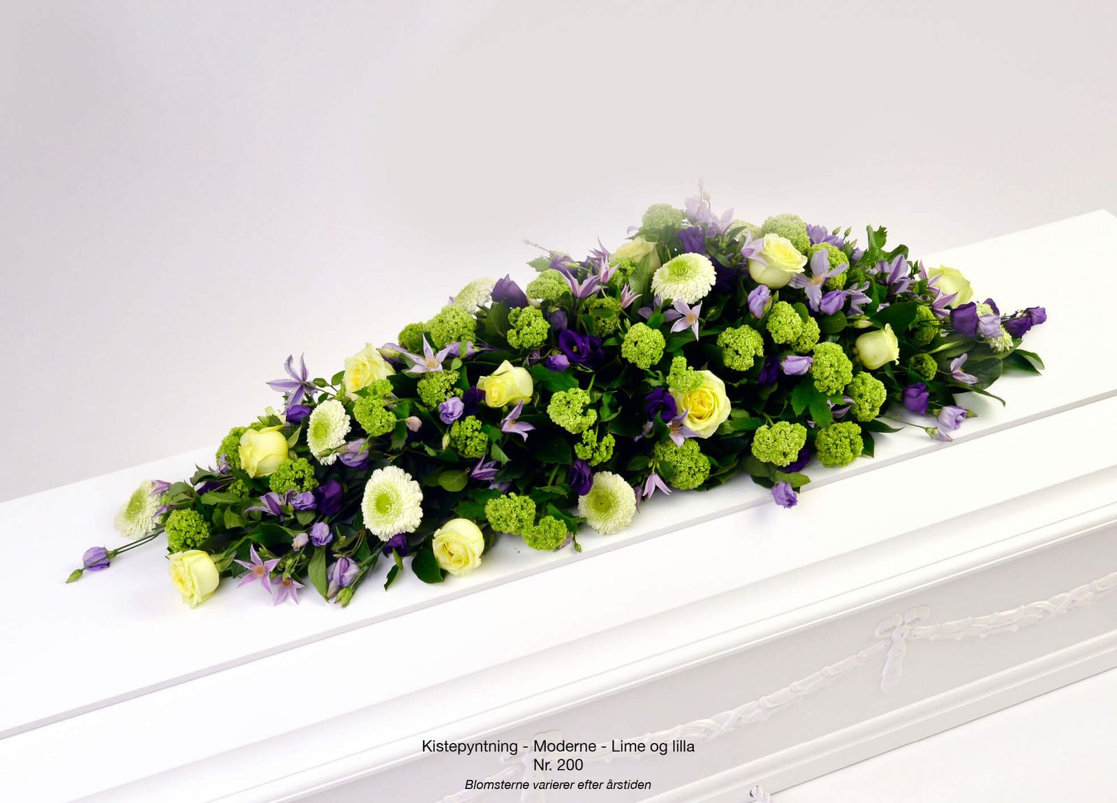 Product photography art direction showcasing purple and lime floral casket spray with roses, gerberas and violas