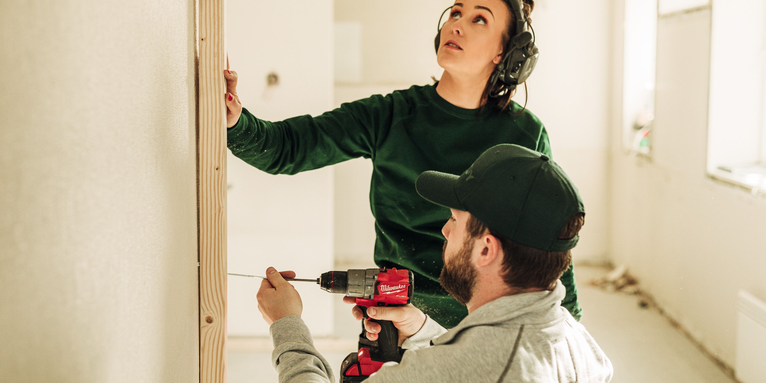 To Steddy håndverkere som pusser opp en vegg