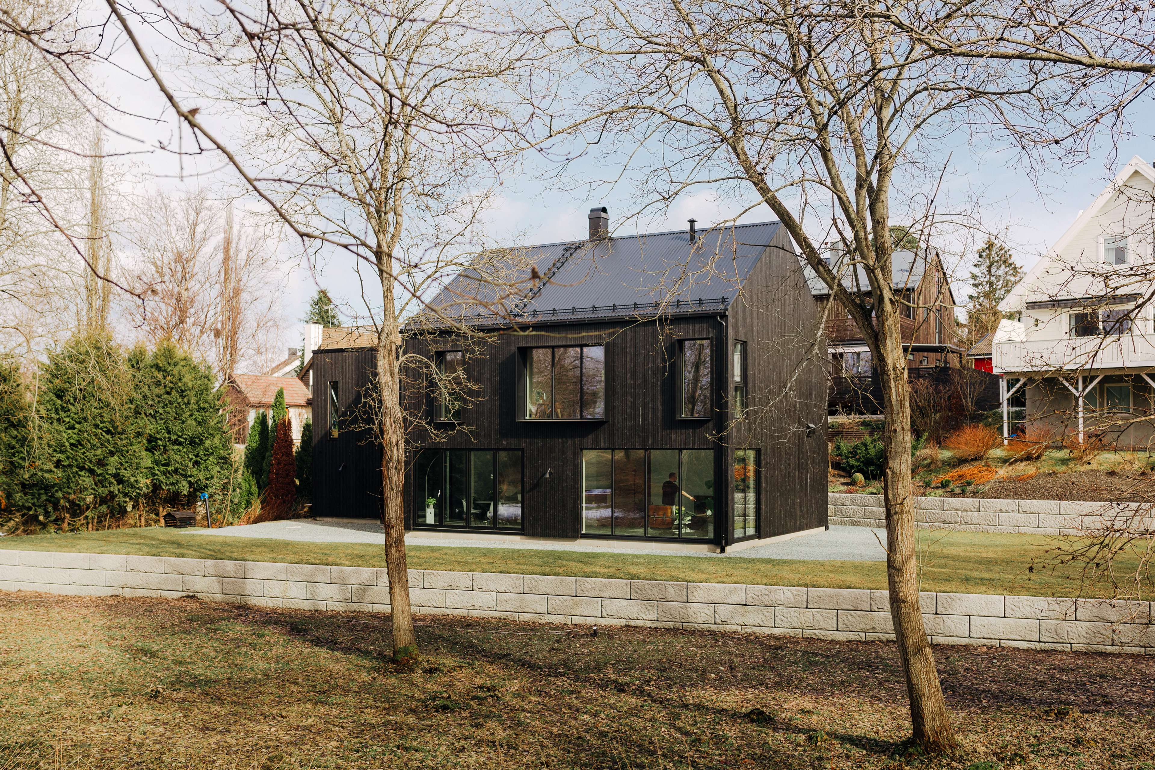 Oversiktsbilde av et moderne hus bak noen trær