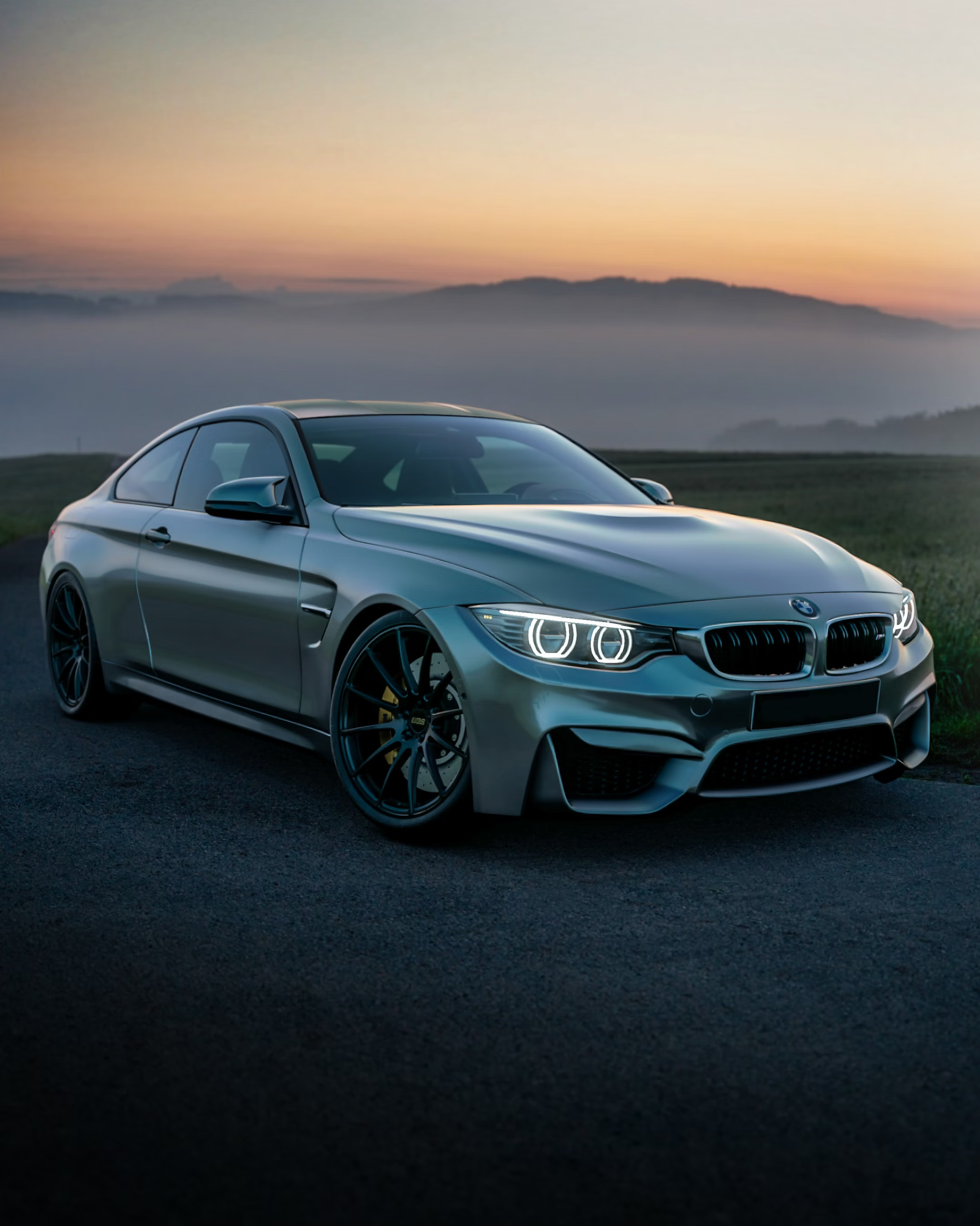Grey coupe parked at dusk