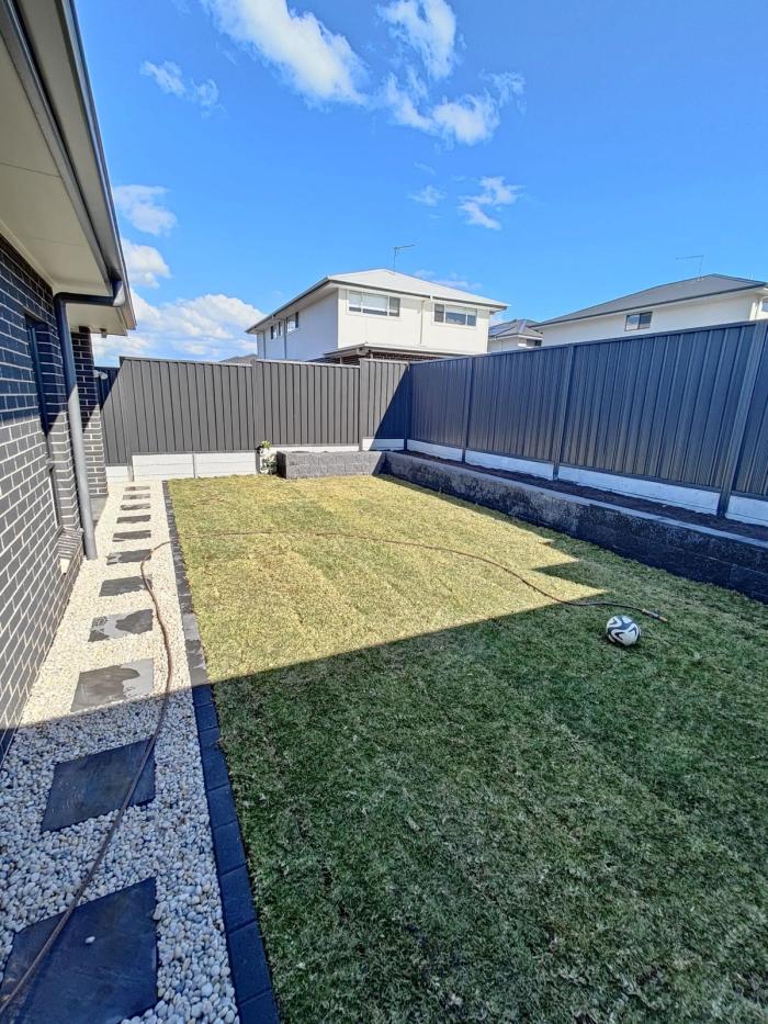 Backyard — turf & retaining wall — after