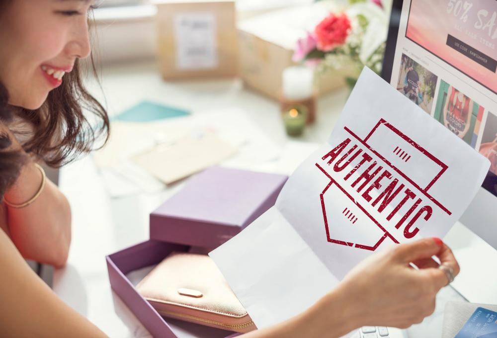 A woman holding a paper that says authentic