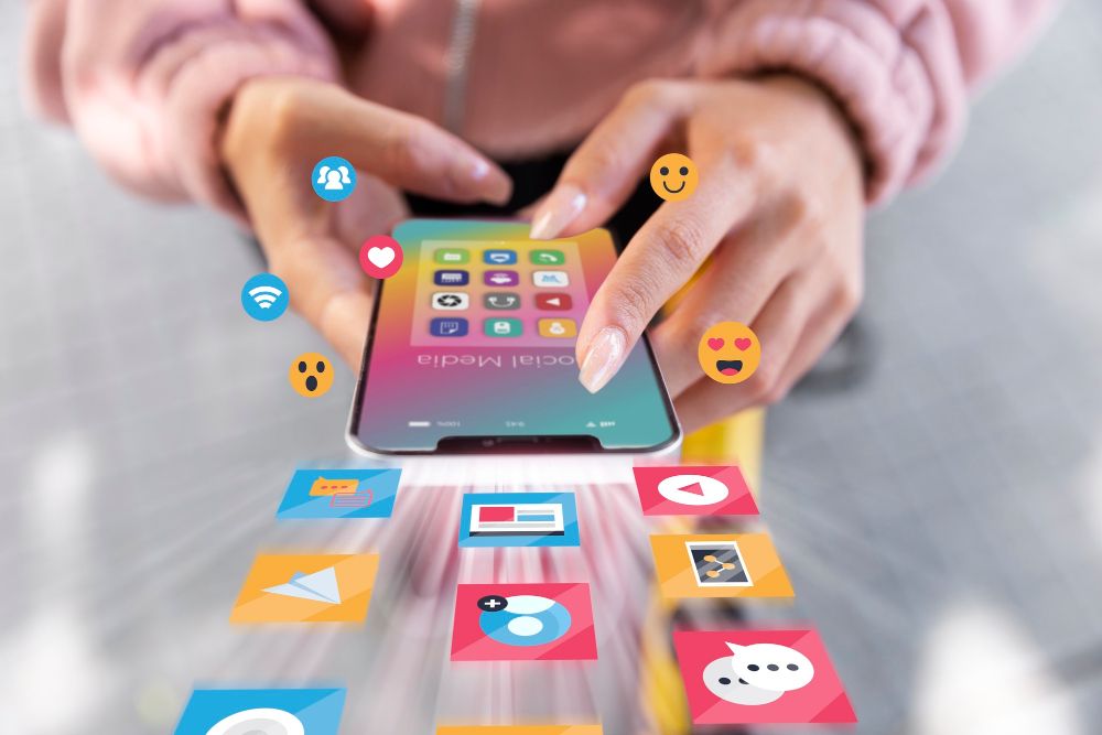 emojis and icons flowing out a phone to show digital marketing
