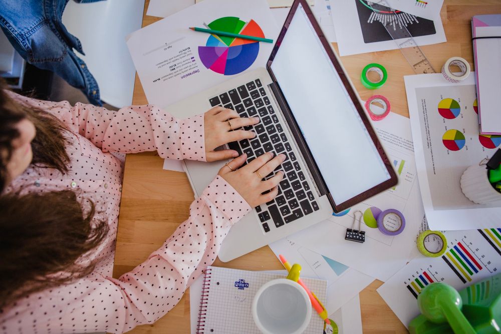 a woman typing on her laptop looking through different marketing strategies