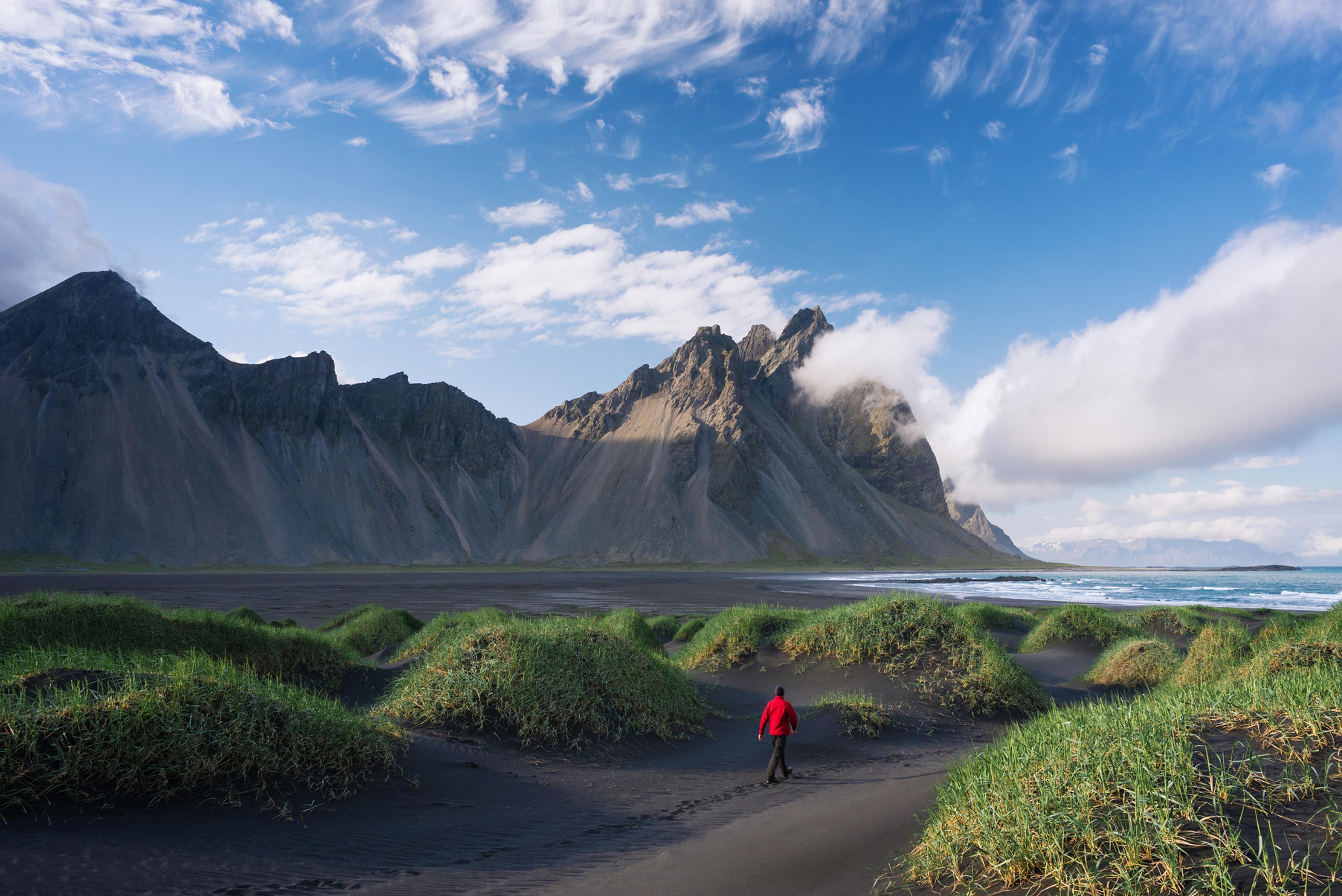 La montaña Vestrahorn reflejada sobre la arena negra mojada de Stokksnes