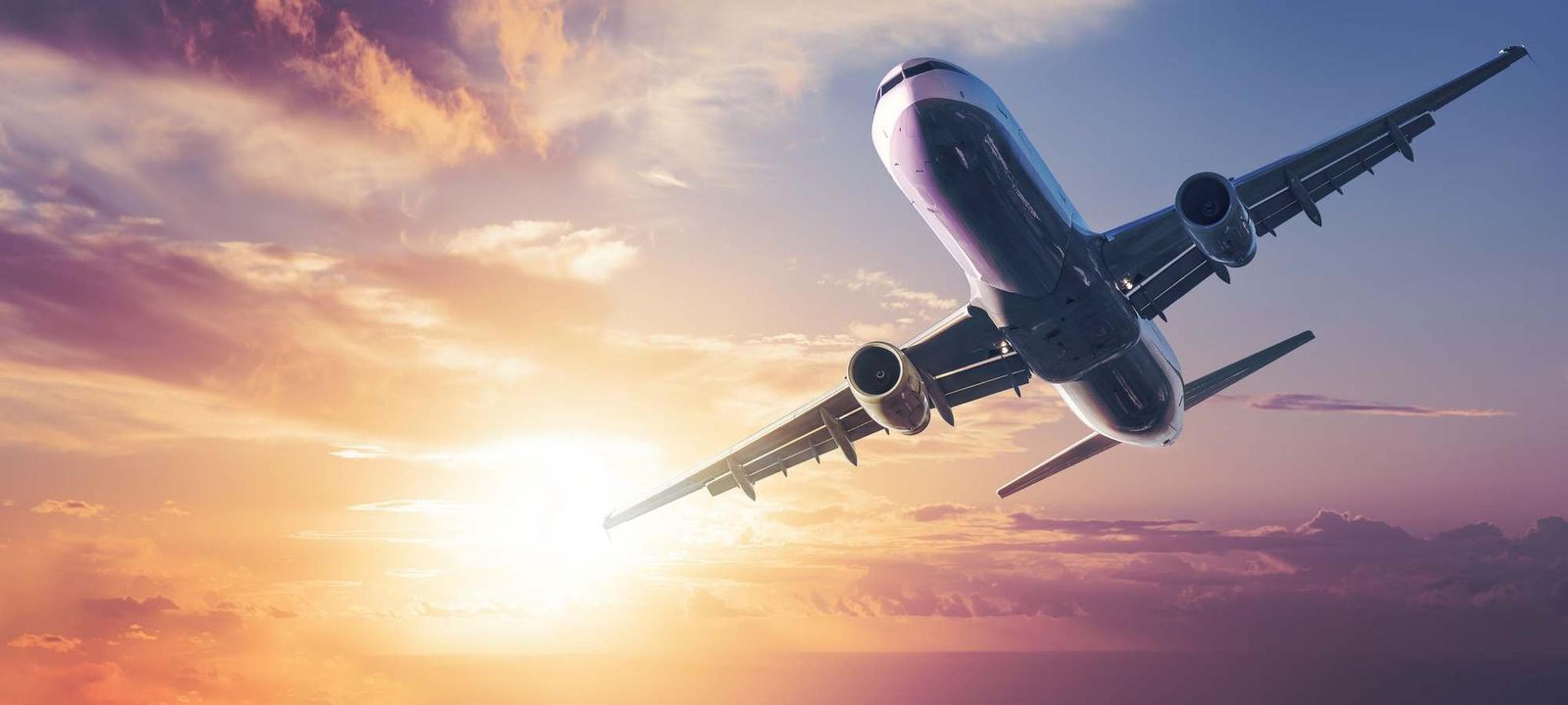 Avión despegando al atardecer con cielo anaranjado
