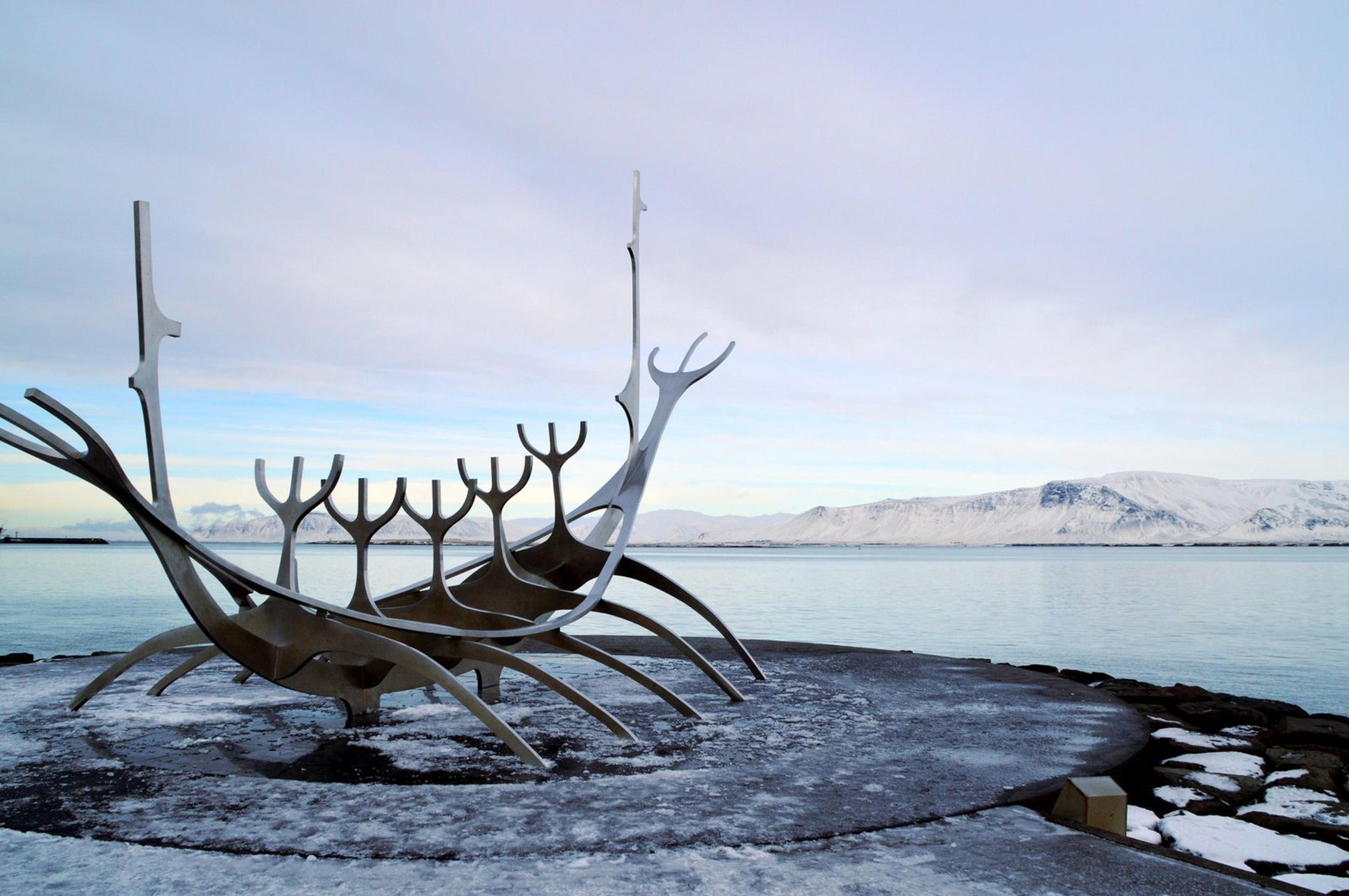 Escultura Sun Voyager junto al mar en Reikiavik, con montañas al fondo