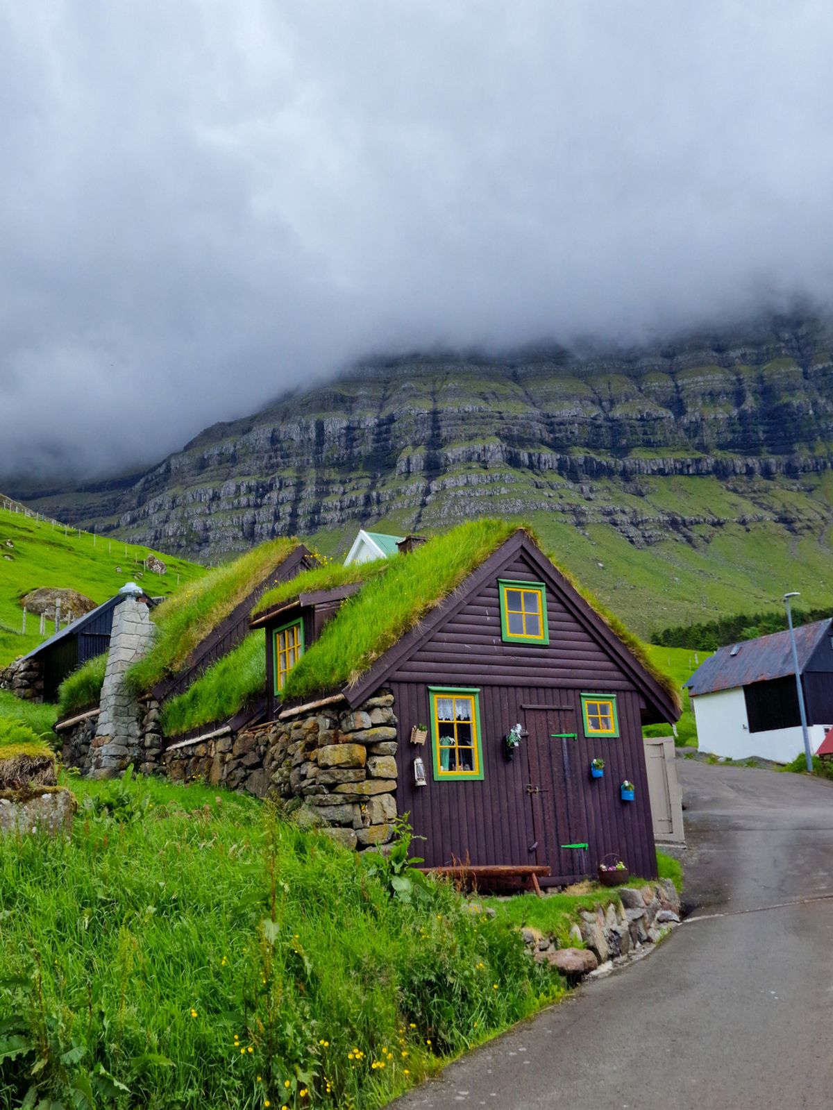 Casa de madera oscura con cubierta de hierba en el pueblo de Gjógv, isla de Eysturoy