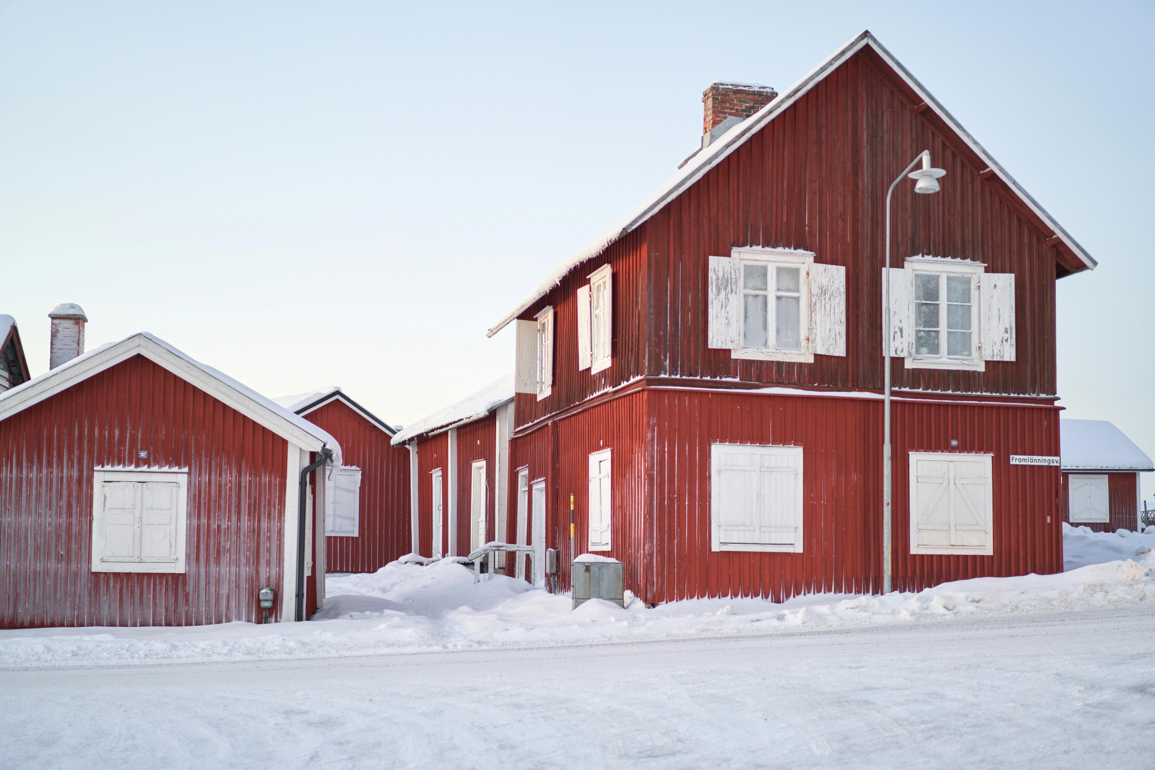 Cabañas de madera roja con nieve en el pueblo iglesia de Gammelstad, Patrimonio de la Humanidad