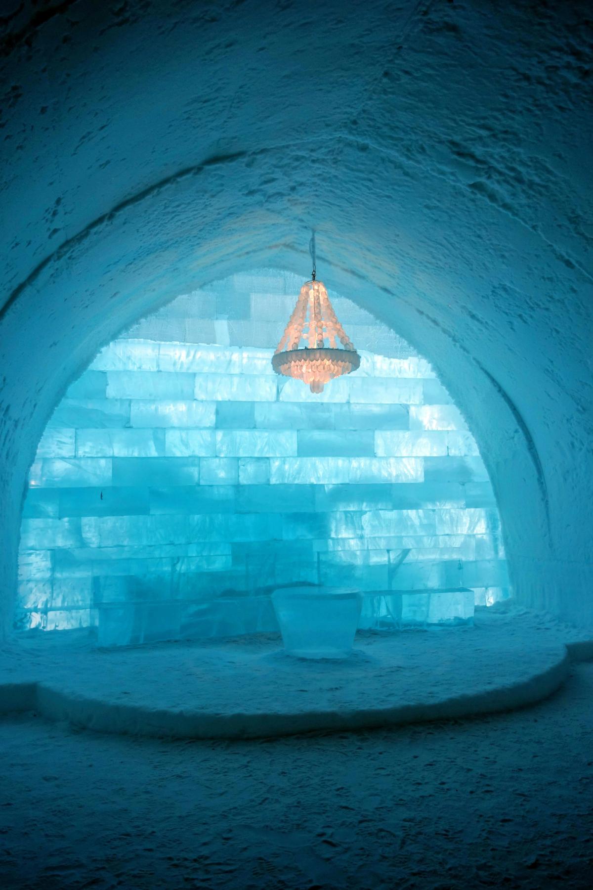 Interior del Hotel de Hielo de Jukkasjärvi con paredes de bloques de hielo y una lámpara de araña helada