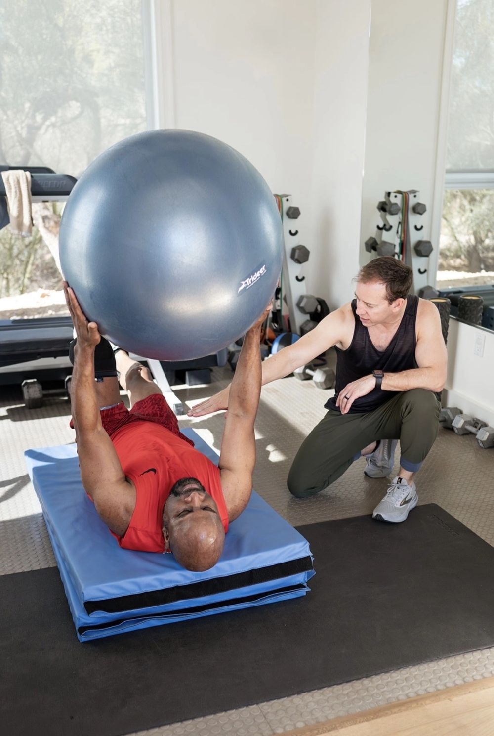 Mike coaching a client through a movement in the gym