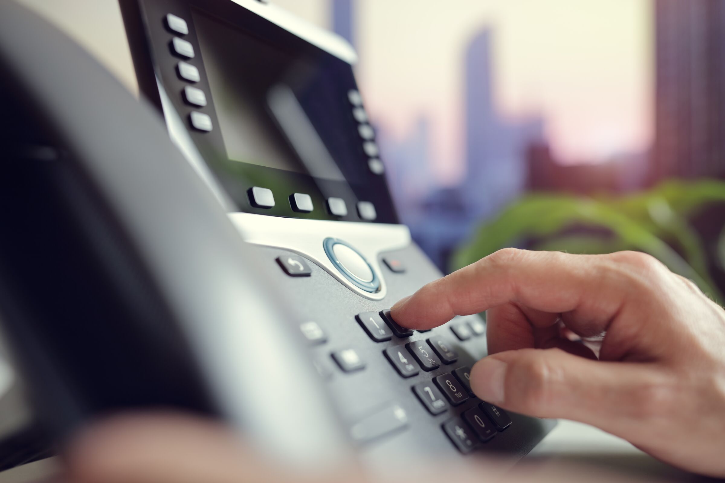 A finger dialling on an office IP desk phone