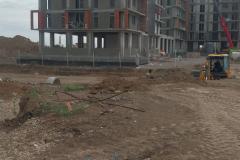 General view of the construction site — buildings at frame stage and the levelled grounds