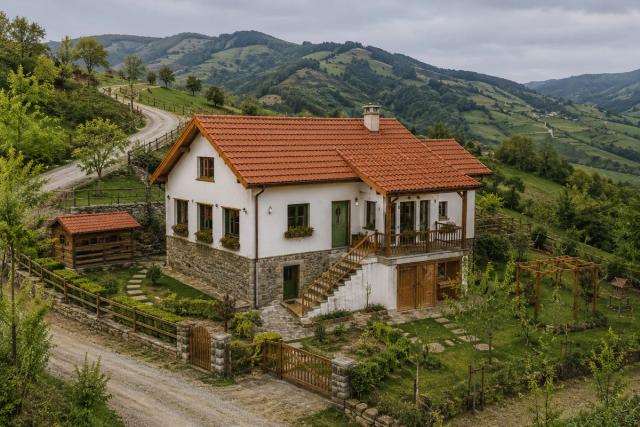 A two-storey private house built in Lachin — white plastered walls, a red tiled roof, a stone plinth and a wooden veranda; mountainous terrain in the background