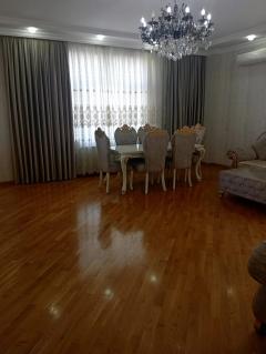 Dining table with chairs, a curtain at the window
