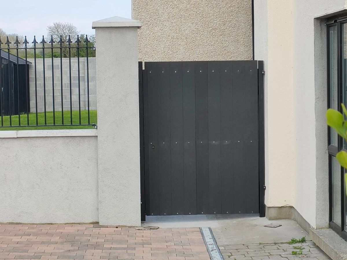 Black sheeted side gate beside a house