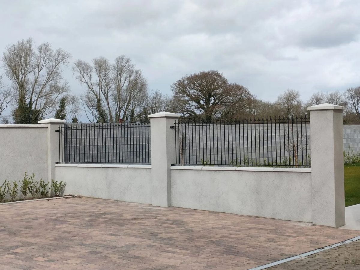 Two runs of black railings along a front wall