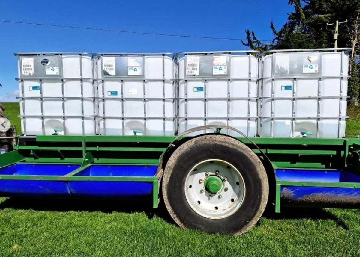 Green mobile water and meal trailer with blue troughs and four water tanks