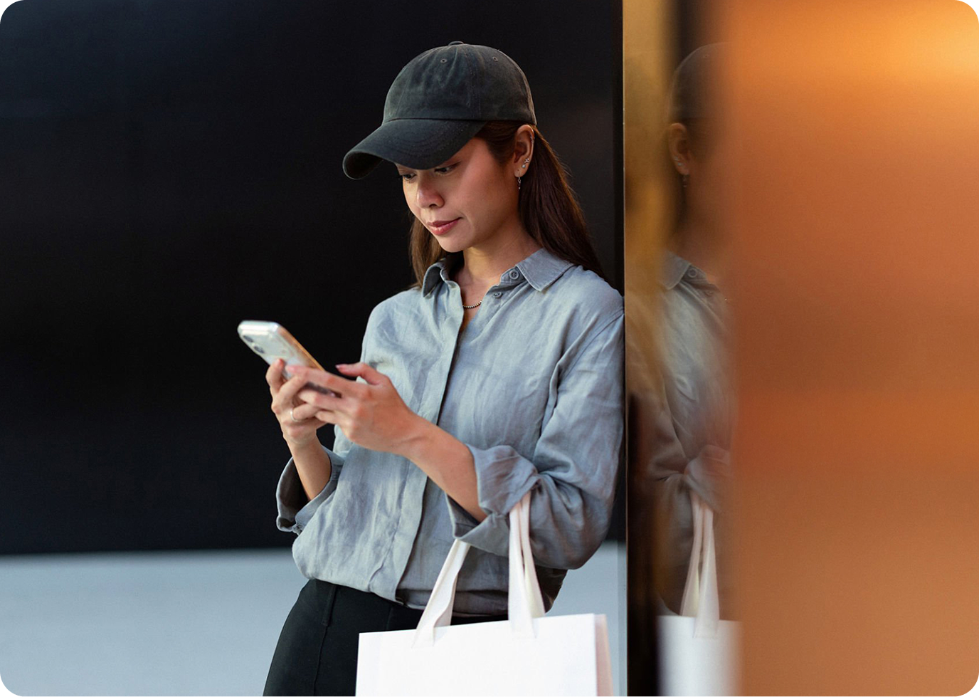 Woman with shopping bag looking at her phone