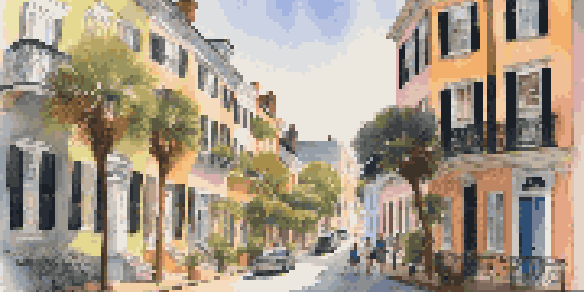 A scenic view of Charleston's Historic District with colorful historic homes and cobblestone streets under warm sunlight.