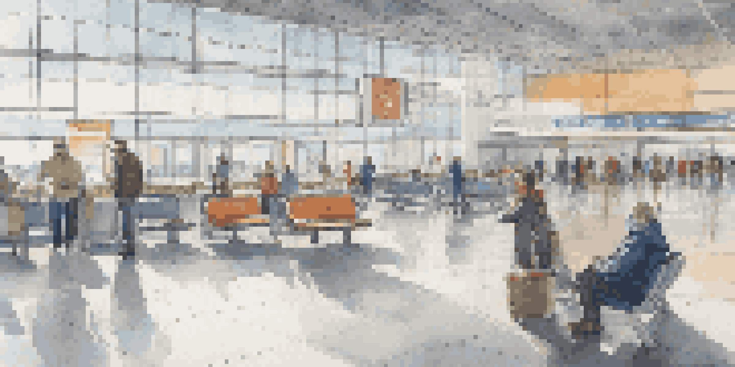 A spacious airport terminal with social distancing signs and spaced seating, showcasing passengers in masks and a bright environment.
