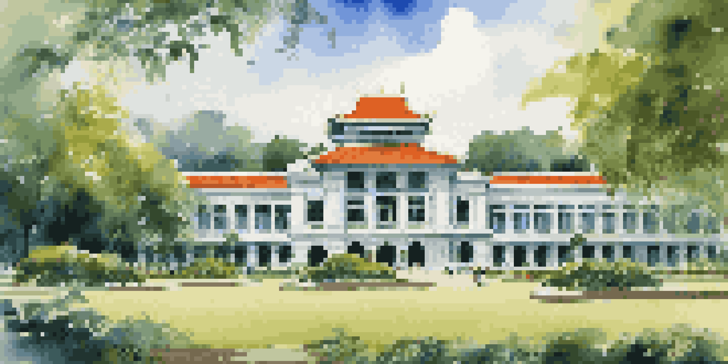 A view of the Reunification Palace with beautiful gardens and visitors, under a clear blue sky.