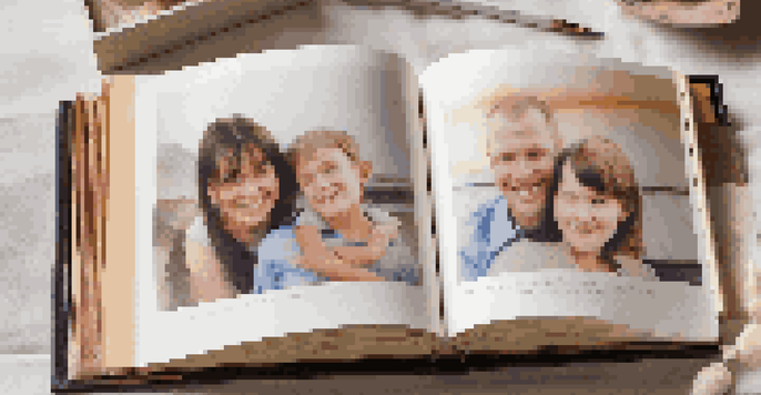 A family photo album with colorful pages and handwritten notes, displayed on a table in warm lighting.