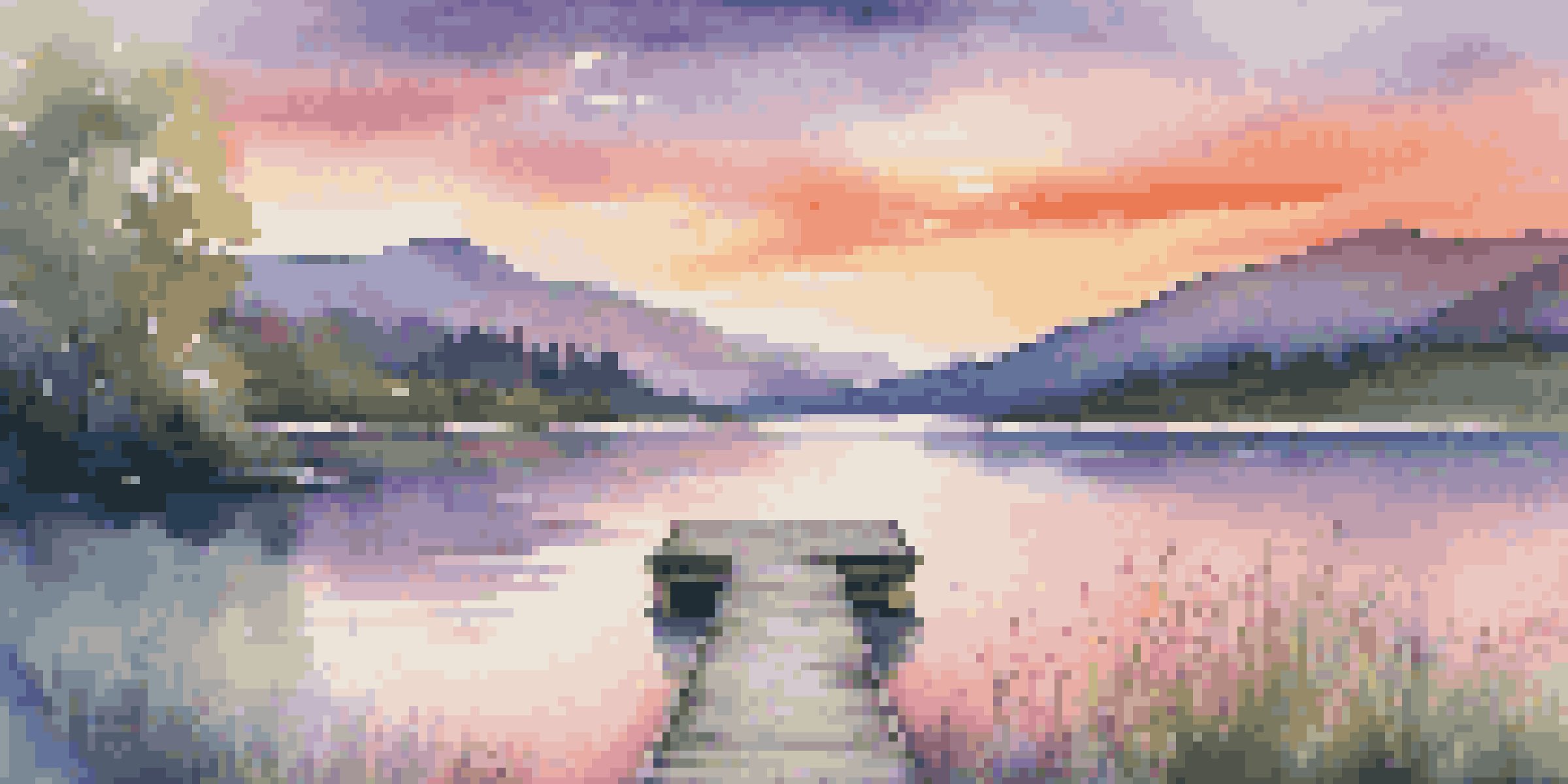 A tranquil lake surrounded by mountains and greenery, with a sunset sky reflecting vibrant colors in the water and a wooden dock in the foreground.