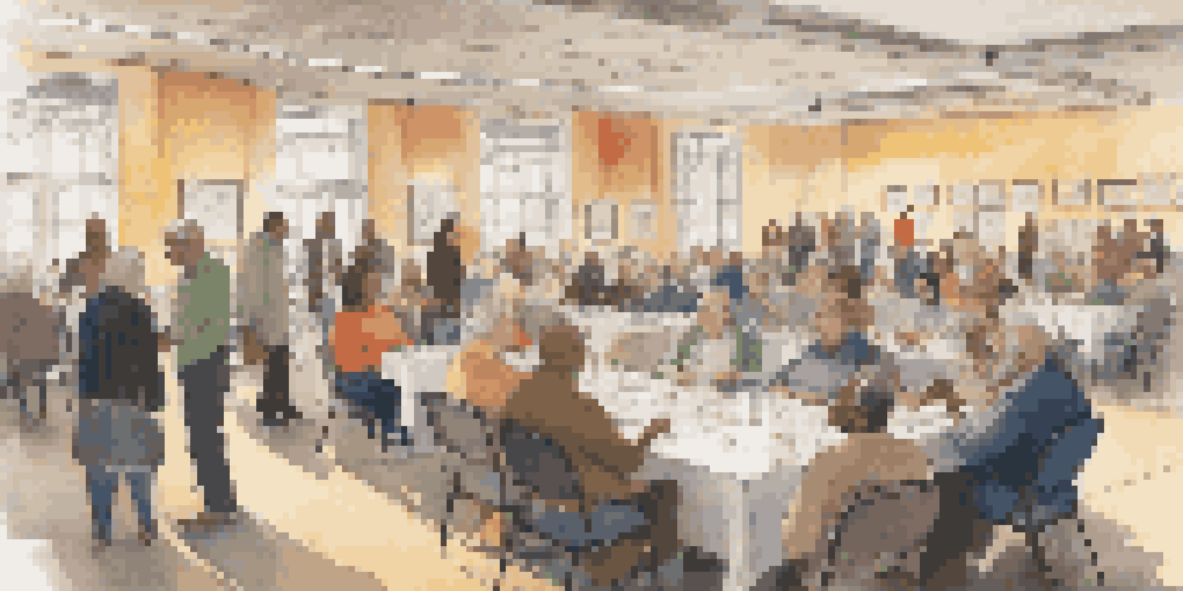 A lively ancestry conference with attendees discussing genealogy, surrounded by tables of resources and warm lighting.