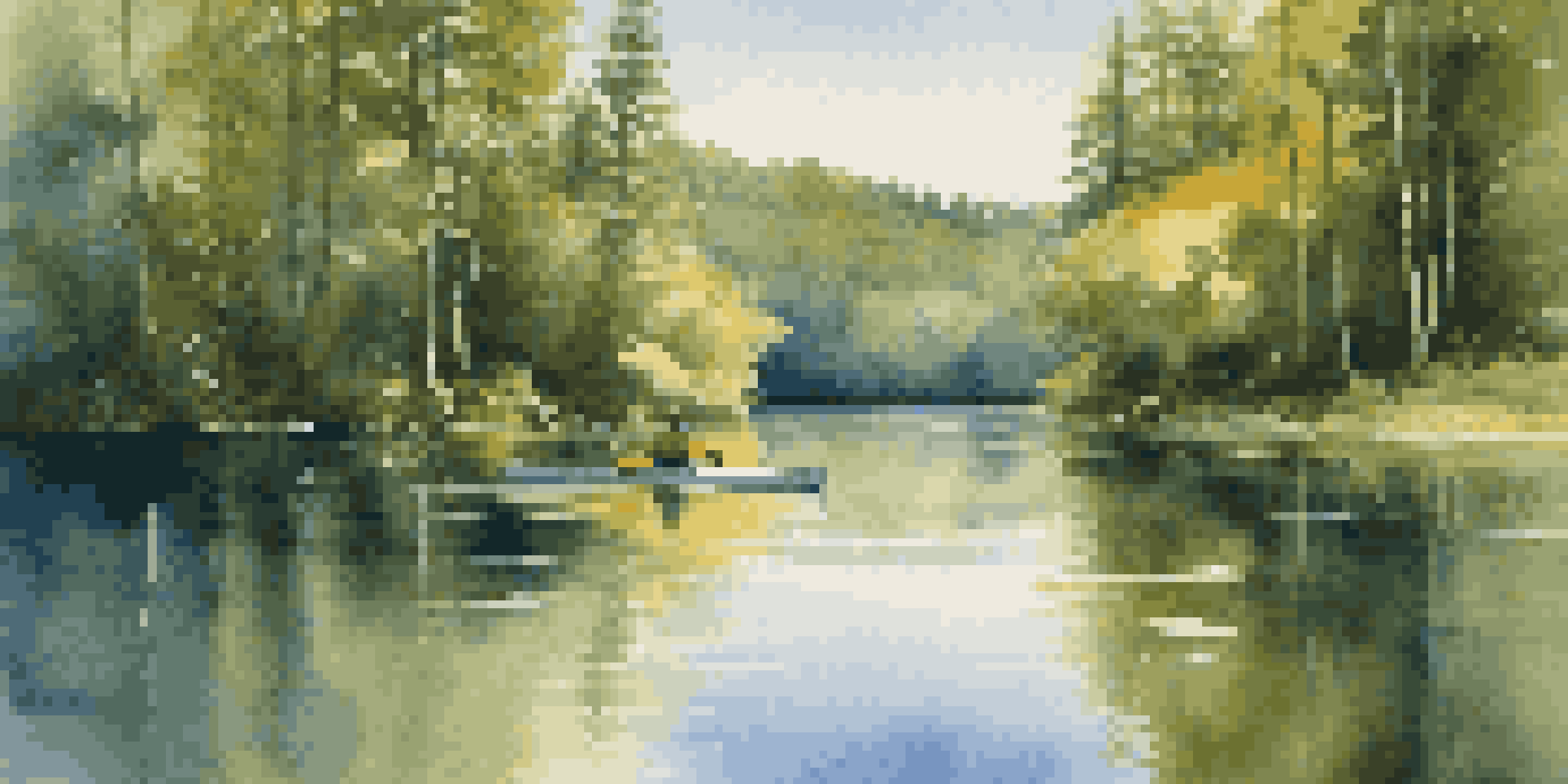 A peaceful lake with a kayaker paddling through calm waters, surrounded by green trees and a clear sky.