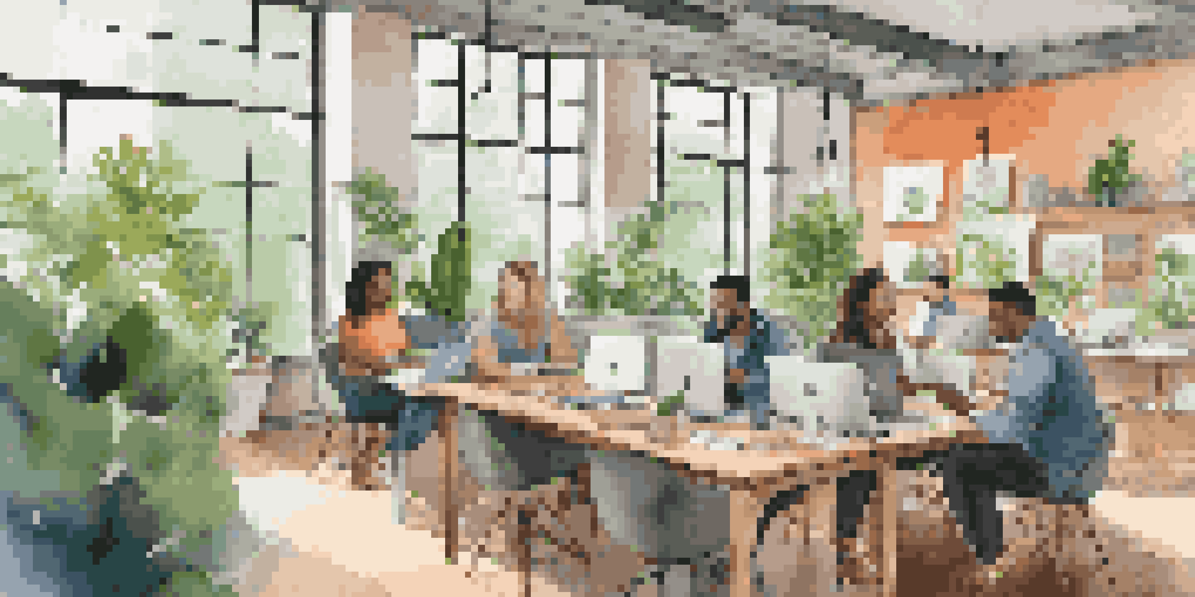 A lively co-working space with professionals at work, greenery, and natural light.