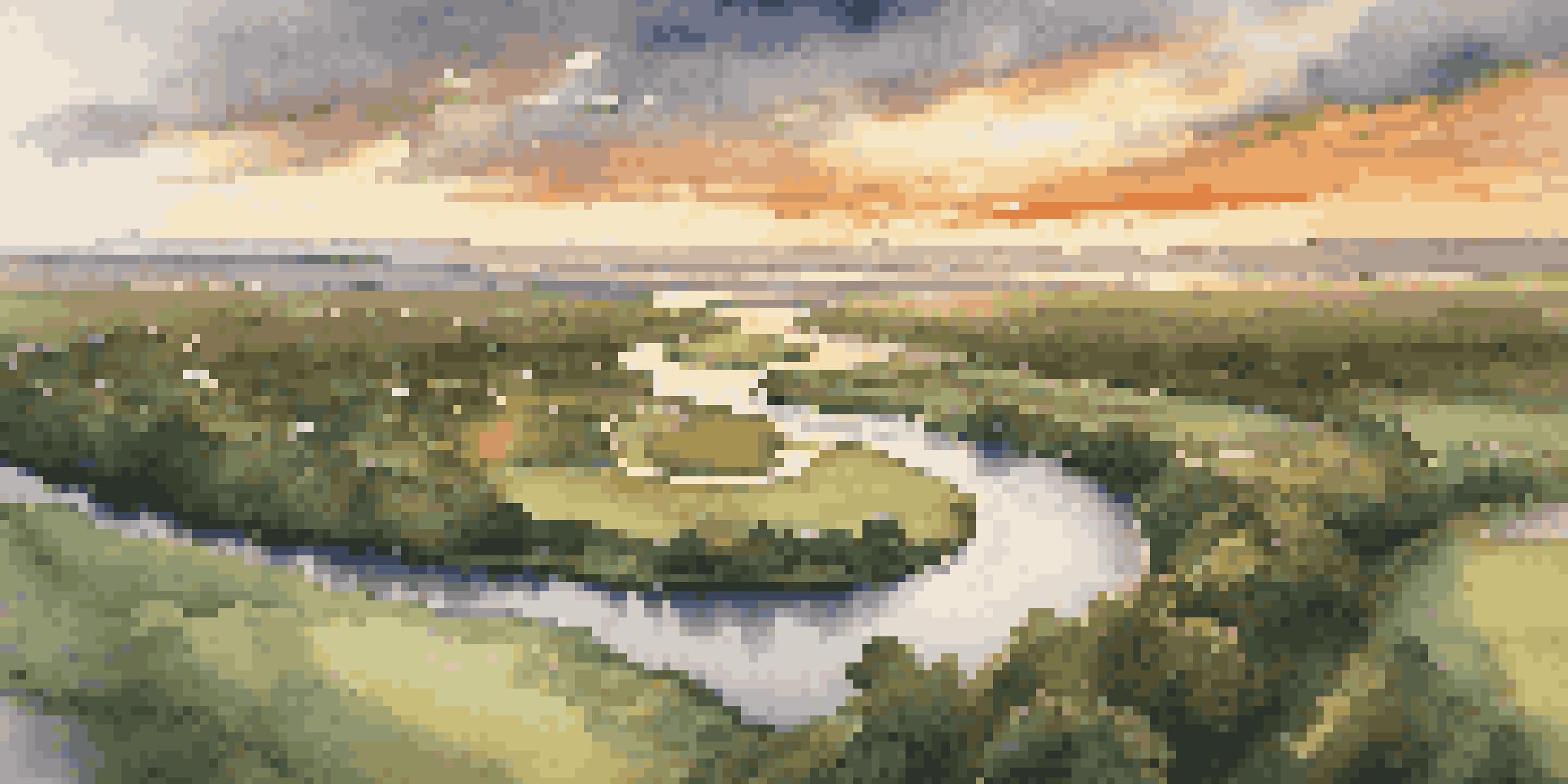 Aerial view of a winding river at sunset, showcasing warm colors and lush greenery.