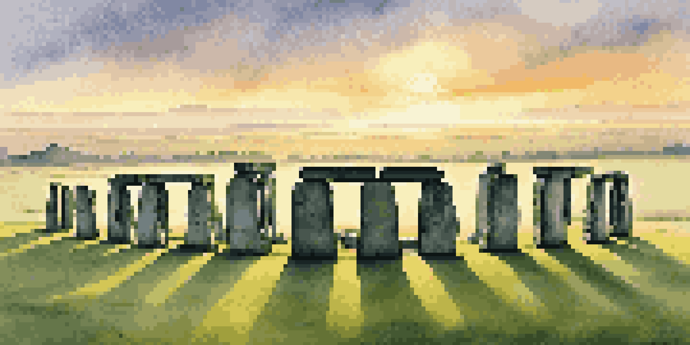 Aerial view of Stonehenge at sunrise, with golden light illuminating the stone circle and surrounding fields.