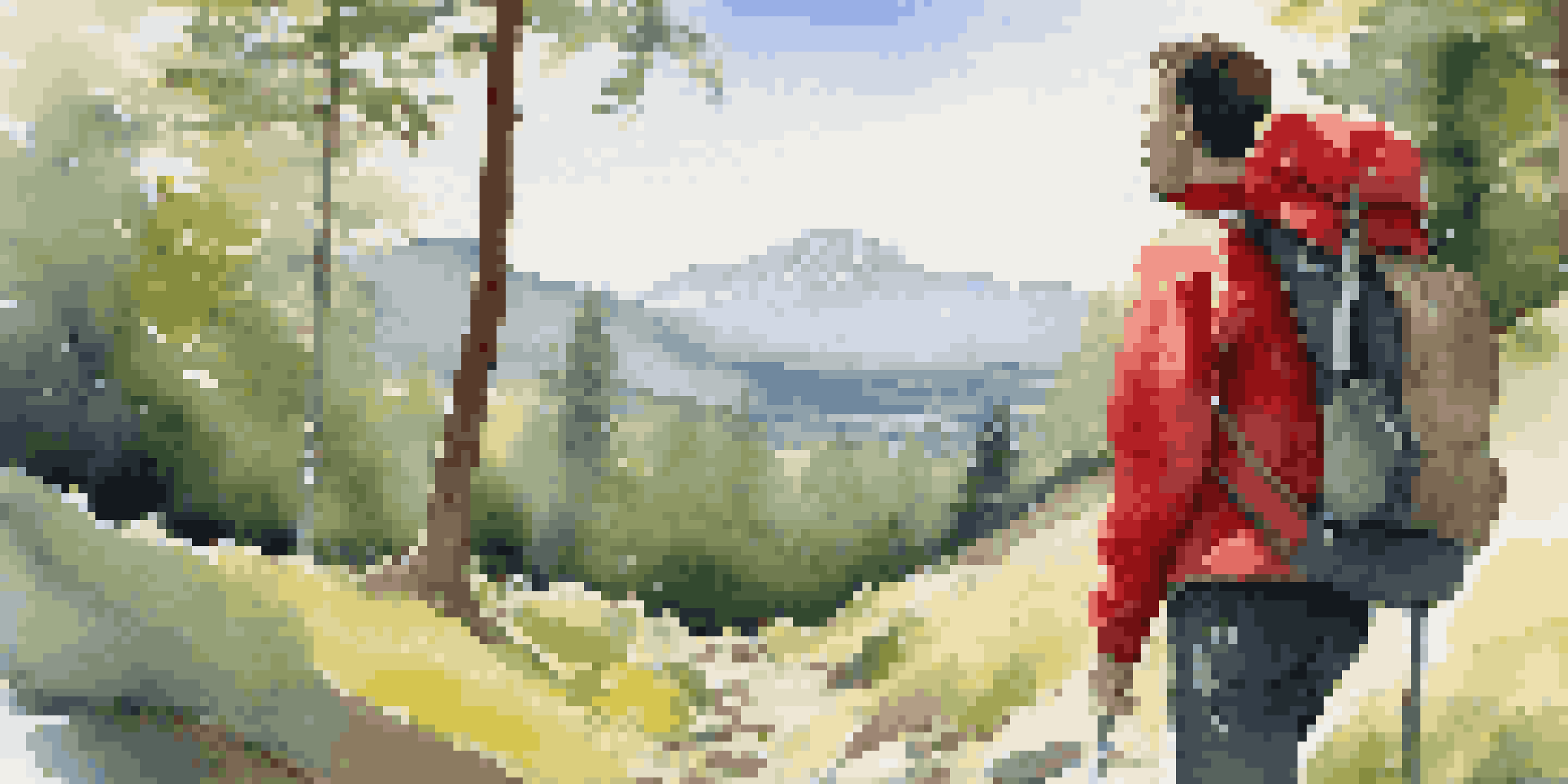 A beginner backpacker in a red jacket standing on a trail, surrounded by trees and mountains in the background.
