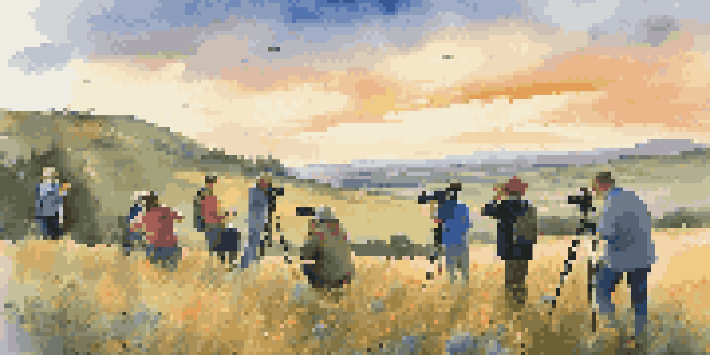 A group of photographers taking pictures in a beautiful landscape during a travel photography workshop at sunset.