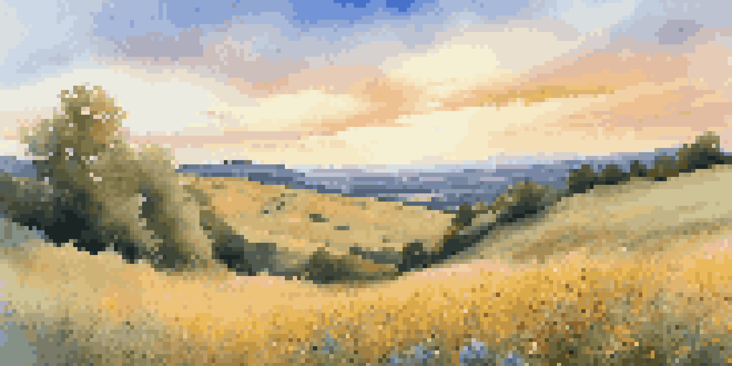A peaceful landscape with rolling hills, colorful wildflowers in the foreground, and a clear blue sky during sunset.