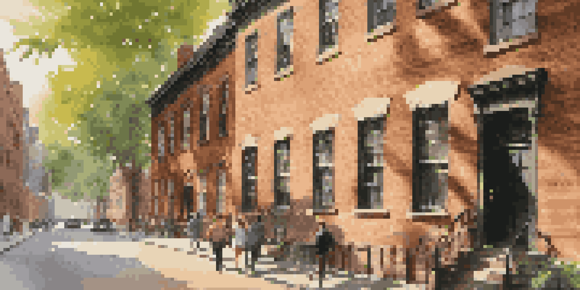 A historic brick building with trees and visitors in Lower Manhattan, illuminated by the afternoon sun.