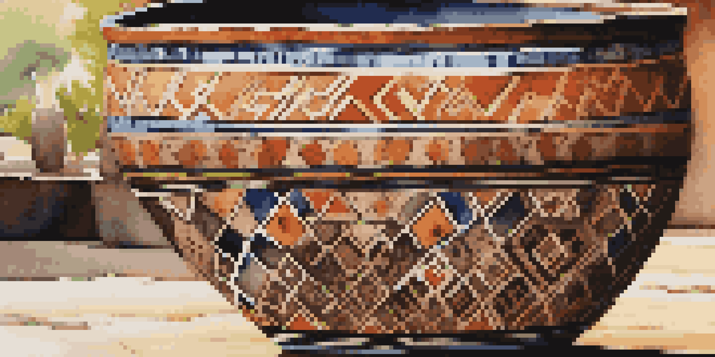 A close-up view of an ancient pottery piece with intricate geometric patterns and vibrant colors, displayed on a rustic wooden table under soft sunlight.