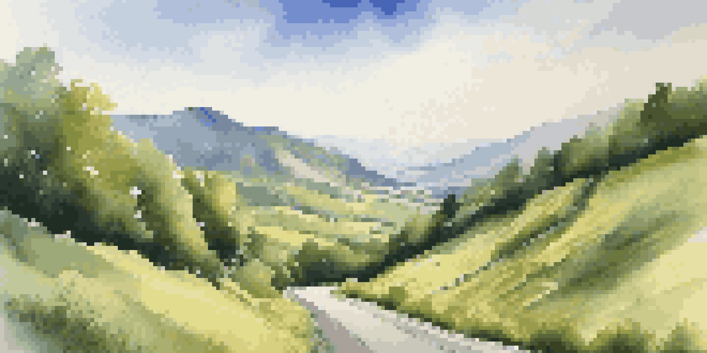 A winding mountain road surrounded by green hills and a clear blue sky.
