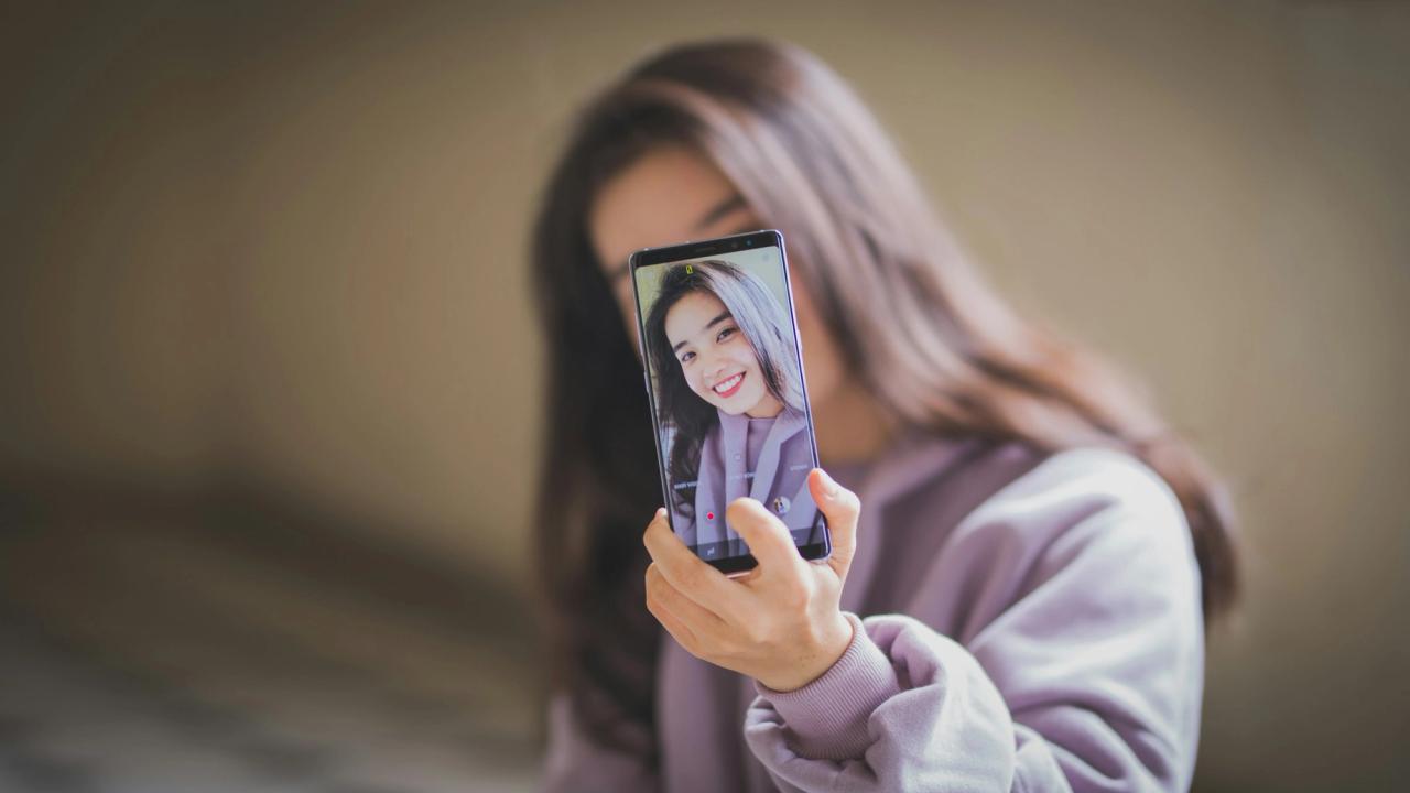A woman taking a selfie with her phone.