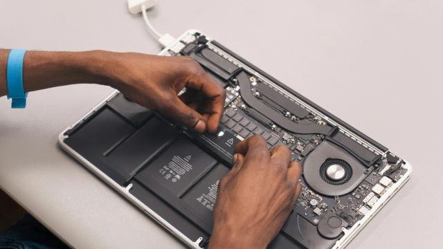 A technician opening up a MacBook Pro to check its insides.