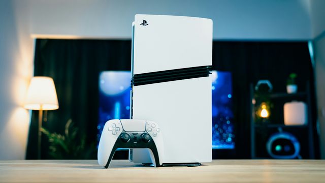 A PlayStation 5 Pro console and its controller on a wooden table.