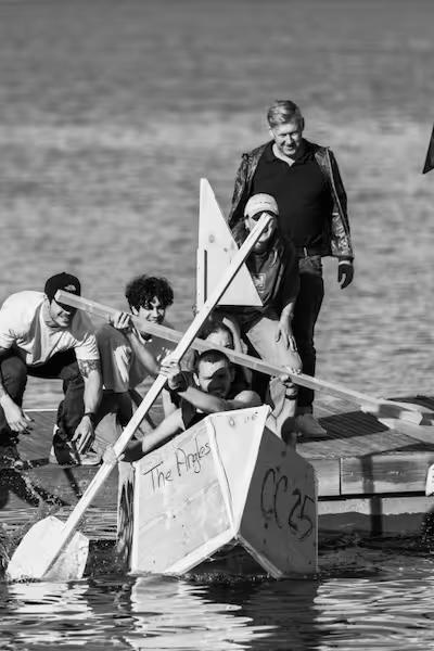 Cortians paddling a homemade boat in a CortiCon boat race