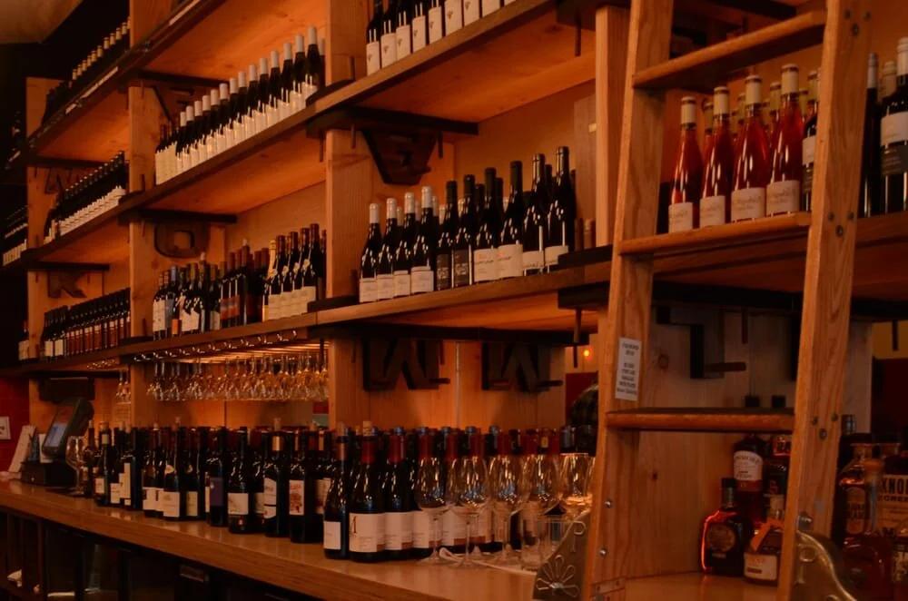 Wine bottles on the shelves behind the bar at Amélie West Village