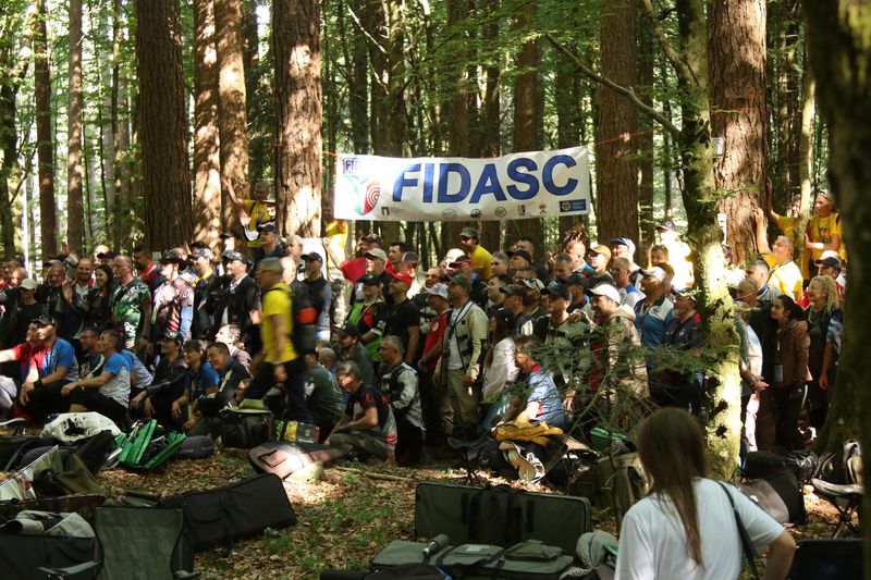Takmičari iz 17 zemalja okupljeni ispod FIDASC banera među borovima