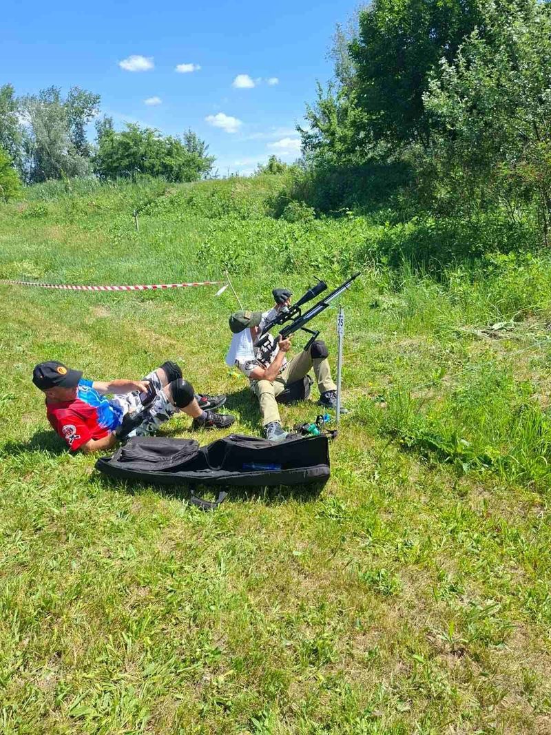 Dva takmičara na susednim stajalištima, jedan ležeći, drugi sedeći