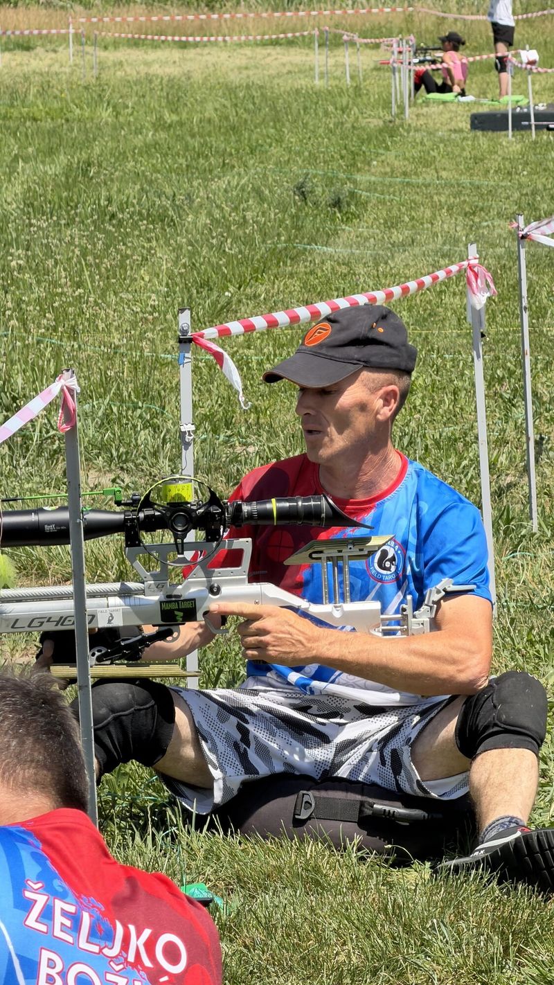 Takmičar sedi uz pušku na stajalištu i čeka red