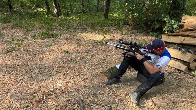 Takmičar u klasičnom Field Target sedećem položaju nišani uzbrdo